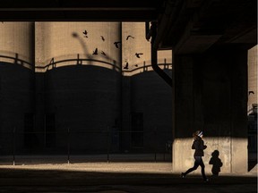 A jogger runs through a shaft of light underneath the Bonaventure Expressway in Montreal on Friday December 18, 2020. Dave Sidaway / Montreal Gazette ORG XMIT: 65518
