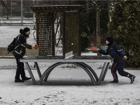 With snow falling, Philippe and his son Alex cleared a ping-pong table to play a spirited match in Loyola park in the Notre-Dame-de-Grâce area of Montreal Sunday, December 20, 2020.