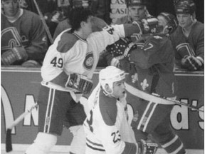 Canadiens' forward Brian Savage pops Nordiques' Claude Lapointe in front of the Nordiques' bench during a game on March 18, 1995.