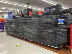 Entire aisles of non-essential goods are covered in plastic wrap at the Walmart store at in Dorval.