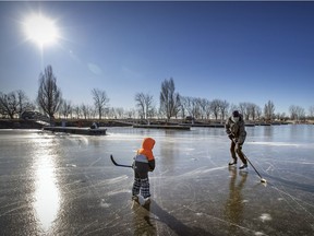 Olivier Boudreault skates with son Charles on the ice in the canal in the Lachine borough of Montreal Tuesday December 29, 2020.