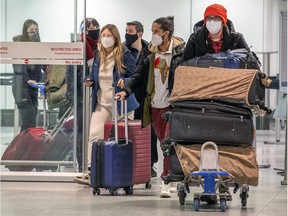 Passengers arrive at Montréal-Pierre Elliott Trudeau International Airport in Montreal Wednesday Dec. 30, 2020.
