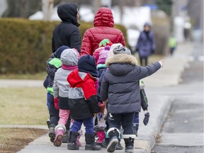 Children from a daycare in Laval, north of  Montreal walk down a street on Dec. 3, 2020.