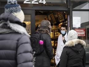 An employee counts clients and gives instructions at the Boucherie du Marche in the Jean Talon Market on Dec. 22, 2020.