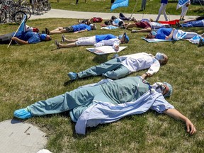 Saying their "dead from fatugue," health-care workers hold a die-in during a demonstration outside Maisonneuve-Rosemont Hospital in Montreal on May 27, 2020.