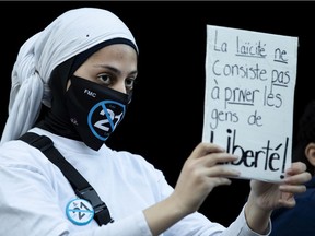 A Muslim woman taking part in an anti Bill 21 protest wears a protective face mask calling for an end to Bill 21, in Montreal, on Sunday, November 8, 2020. (Allen McInnis / MONTREAL GAZETTE) ORG XMIT: 65