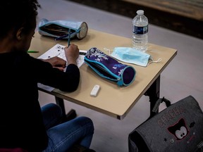 A pupil is at work in a classroom, on May 14, 2020 at a school in Lyon, as primary schools in France re-open this week and the country eases lockdown measures taken to curb the spread of the COVID-19 (the novel coronavirus). (Photo by JEFF PACHOUD / AFP)