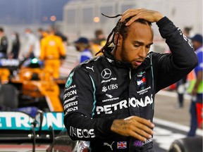Mercedes' British driver Lewis Hamilton steps out of his car after winning the Bahrain Formula One Grand Prix at the Bahrain International Circuit in the city of Sakhir Nov. 29, 2020.