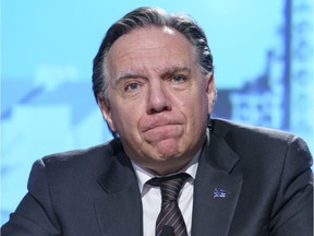 Quebec Premier Francois Legault purses his lips as he listens to a question during a news conference in Montreal, Tuesday, Dec. 8, 2020.