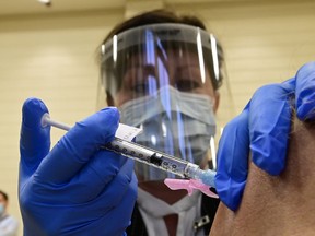 A patient receives the Pfizer/BoiNTech vaccine at Toronto University Health Network Safety Services