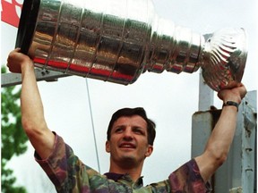 Montreal Canadiens captain Guy Carbonneau hoists the Stanley Cup during parade in Montreal on June 11, 1993.