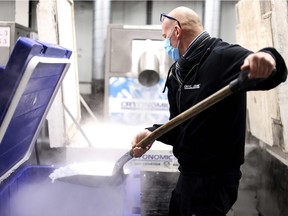 An employee of Cryonomic, a Belgian company producing dry ice machines and containers that will be used for the transport of COVID-19 vaccines, prepares dry ice pellets in Ghent on December 2, 2020.