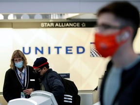 United Airlines agent helps a customer check in for his flight at O'Hare International Airport ahead of the Thanksgiving holiday during the coronavirus disease (COVID-19) pandemic, in Chicago, on Nov. 25, 2020.