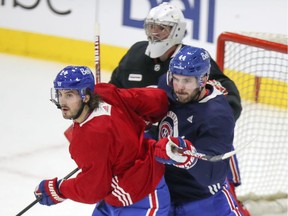 Canadiens forward Phillip Danault battles for position in front of goalie Carey Price while being checked by defenceman Joel Edmundson during training-camp practice at the Bell Sports Complex in Brossard.