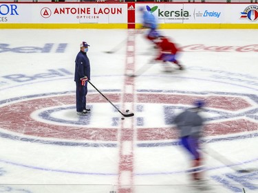 Head coach Claude Julien stands at centre ice as players skate around him during Montreal Canadiens training camp practice at the Bell Sports Complex in Brossard on Tuesday Jan. 5, 2021.