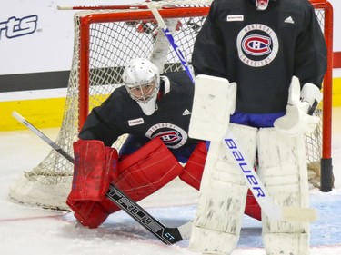 Carey Price peaks around a screen set by Jake Allen during Montreal Canadiens training camp practice at the Bell Sports Complex in Brossard on Wednesday, January 6, 2021.