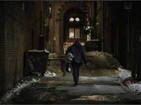 A homeless man walks in a lane near Ste-Catherine St. and Metcalfe Sts. A petition urging the government to lift its curfew for homeless people has been tabled at the National Assembly.