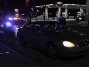 A police officer speaks to a driver on St-Laurent Blvd. on the first night of Quebec's curfew – Saturday, January 9, 2021.
