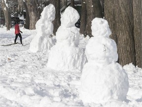 Snowmen looking much like the Easter Island statues, line the paths of Jeanne-Mance park on Jan. 18, 2021