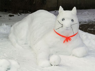 A giant snow cat with casino chips for eyes sculpted on a lawn on 51st. Ave. in the Lachine borough of Montreal on Jan. 18, 2021.