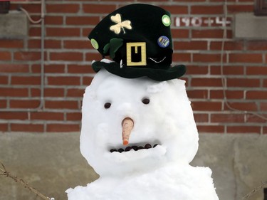 A snowman dressed for the St. Patrick's Day Parade on the lawn of an apartment building on 45th. Ave. in the Lachine borough of Montreal on Jan. 18, 2021.