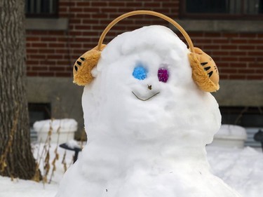 A snowman wears earmuffs on the lawn of an apartment building on 45th. Ave. in the Lachine borough of Montreal on Jan. 18, 2021.