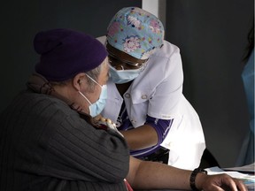 A health-care worker gives a COVID-19 vaccination as the Welcome Hall Mission works to get Montreal's homeless population protected on Jan. 19, 2021.