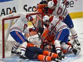 Montreal Canadiens players crowd the Edmonton Oilers' net and goalie Mikko Koskinen trying to jam in the puck at Rogers Place in Edmonton on Jan. 18, 2021.