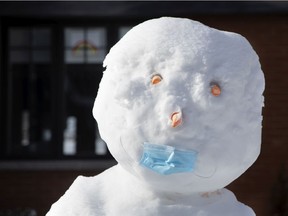 MONTREAL, QUE.: January 20, 2021 -- A snowman sports a procedure mask outside a home in Montreal, on Wednesday, January 20, 2021. (Allen McInnis / MONTREAL GAZETTE) ORG XMIT: 65641