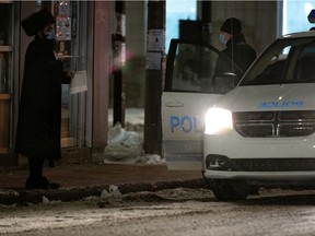 Montreal police speak with a man out past curfew on Jan. 23, 2021.