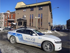 A police car drives past a synagogue in the Outremont. Officers intervened amid confusion over the number of people allowed inside.
