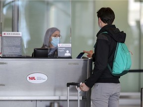 A traveller checks in for a flight to the United States at Montréal–Trudeau International Airport on Tuesday, January 26, 2021.