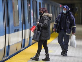 Masked Metro riders wait for the train doors to open in Montreal.