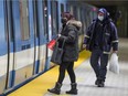 Masked métro riders wait for the train doors to open in Montreal in January 2021.