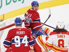 Canadiens' Brendan Gallagher (11) celebrates his power-play goal with teammate Corey Perry, while Calgary Flames' Christopher Tanev (8) looks on, during first period NHL action in Montreal on Thursday January 28, 2021.
