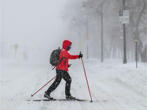 A cross-country skier crosses Park Ave. during snowstorm in Montreal.