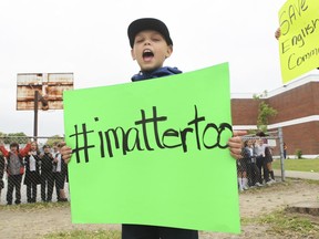 Students, former students, parents and teachers take part in a 'human chain' protest outside of Dante School in the St. Léonard area in Montreal, on Thursday, June 20, 2019.