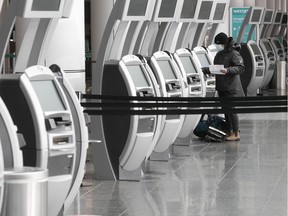 A lone passenger uses the automatic check-in counter at Montreal-Trudeau airport.
