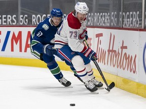 Canadiens' Tyler Toffoli picks up the loose puck while being chased by Canucks' Tyler Myers Wednesday night at Rogers Arena in Vancouver.