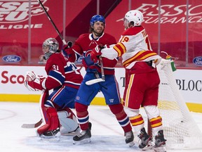 Canadiens defence Ben Chiarot keeps Calgary Flames forward Matthew Tkachuk from getting to the front of the net while goalie Carey Price follows the puck during action Thursday night at the Bell Centre.
