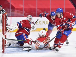 Canadiens goaltender Jake Allen makes a skate save as teammates Alexander Romanov (27) and Brendan Gallagher defend against Joakim Nordstrom (20) of the Calgary Flames during the third period at the Bell Centre on Saturday, Jan. 30, 2021, in Montreal.