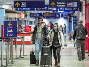 A couple walk sthrough the arrivals area at Montreal's Trudeau airport on Wednesday, Dec. 30, 2020.