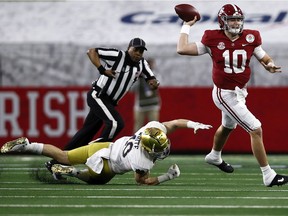 Quarterback Mac Jones of the Alabama Crimson Tide delivers a pass over linebacker Drew White of the Notre Dame Fighting Irish during the first quarter of the 2021 College Football Playoff Semifinal Game at the Rose Bowl Game on Friday, Jan. 1, 2021, in Arlington, Tex.