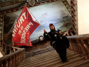 A protester holds a Trump flag inside the US Capitol Building near the Senate Chamber on January 06, 2021 in Washington, DC. Congress held a joint session today to ratify President-elect Joe Biden's 306-232 Electoral College win over President Donald Trump. A group of Republican senators said they would reject the Electoral College votes of several states unless Congress appointed a commission to audit the election results.