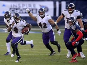 Quarterback Lamar Jackson (8) of the Baltimore Ravens carries the ball for yardage during the fourth quarter of their AFC Wild Card Playoff game against the Tennessee Titans at Nissan Stadium on Sunday, Jan. 10, 2021, in Nashville.