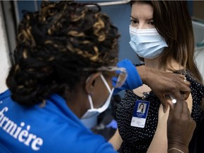 Nurse Gina Valcourt administers the Pfizer-BioNTech COVID-19 vaccine to Dr. Samantha Kellett on Friday, Jan. 8, 2021.