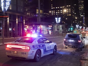 A car is pulled over by a police cruiser in Montreal, Saturday, January 9, 2021. A curfew is in place between 8 p.m. and 5 a.m.