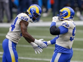 Los Angeles Rams defensive end Aaron Donald (right) celebrates with outside linebacker Leonard Floyd (left) following a sack against the Seattle Seahawks during NFL playoff action at Lumen Field in Seattle on Saturday, Jan. 9, 2021.