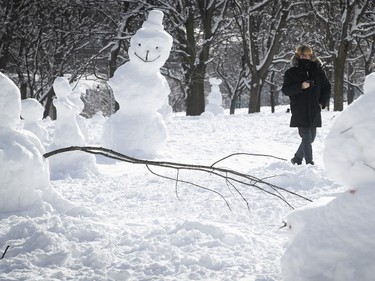 Ray Halls gets a closer look at the snowmen and snow sculptures in Jeanne-Mance Park on Monday, Jan. 18, 2021.