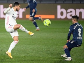 Real Madrid's Belgian forward Eden Hazard, left, challenges Celta Vigo's Spanish midfielder Fran Beltran during the Spanish League football match between Real Madrid and Celta Vigo at the Alfredo Di Stefano stadium in Valdebebas, northeast of Madrid, on Saturday, Jan. 2, 2021.